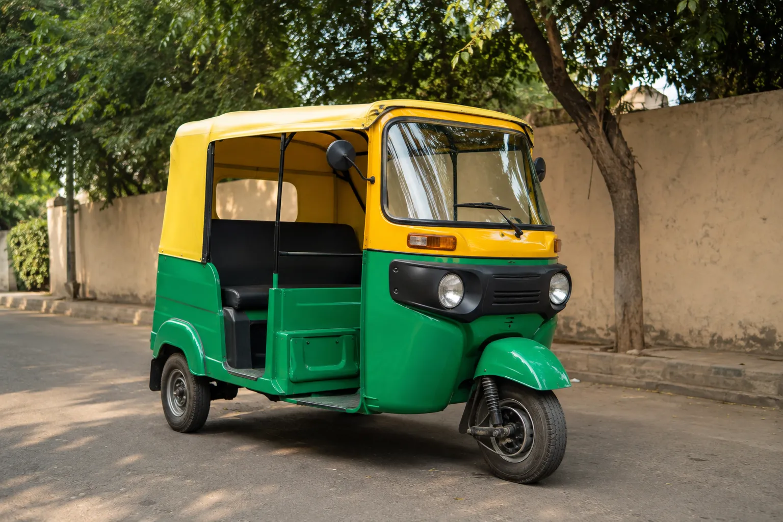An electric auto-rickshaw parked on a quiet street in morning light