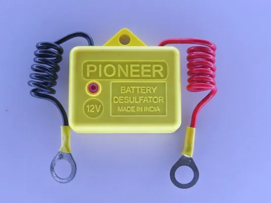 The yellow Pioneer battery desulfator seen from above, with its coiled black and red leads ending in ring terminals